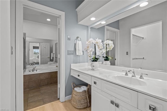 bathroom featuring ensuite bath and vanity