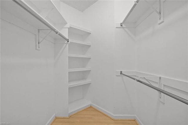 walk in closet with light wood-style flooring