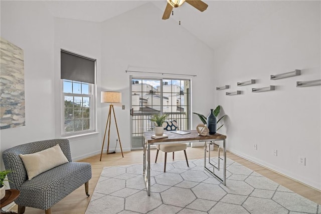 office featuring light wood-type flooring, baseboards, high vaulted ceiling, and ceiling fan