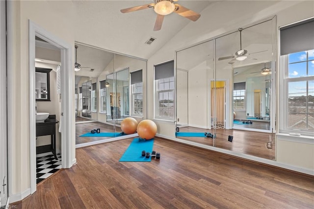 exercise area with vaulted ceiling, a ceiling fan, and visible vents