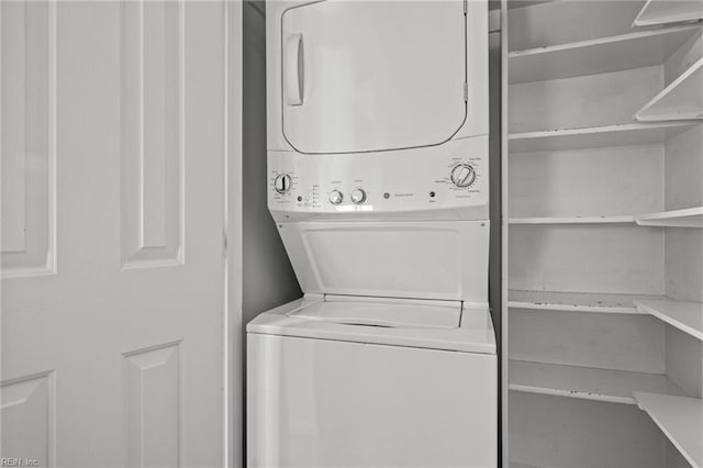 washroom with stacked washer / drying machine and laundry area