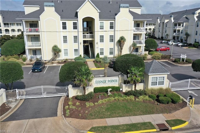 view of property featuring uncovered parking, a residential view, and fence