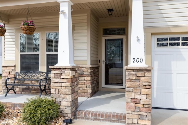 entrance to property featuring covered porch and stone siding