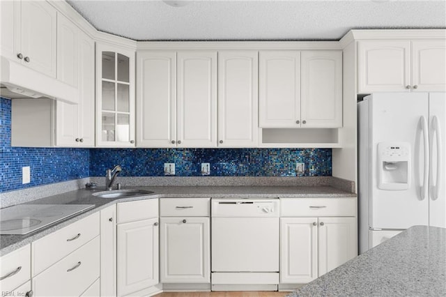 kitchen featuring white appliances, white cabinets, glass insert cabinets, and a sink