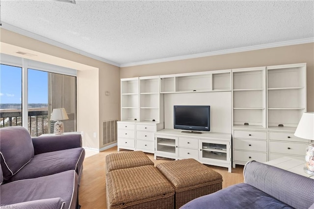living room featuring a textured ceiling, visible vents, light wood finished floors, and ornamental molding