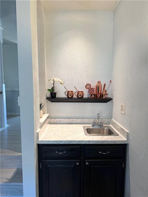 bathroom featuring vanity, wood finished floors, and a textured wall