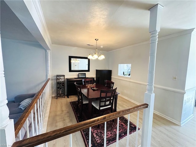 dining area featuring a chandelier, light wood-style flooring, baseboards, and ornamental molding