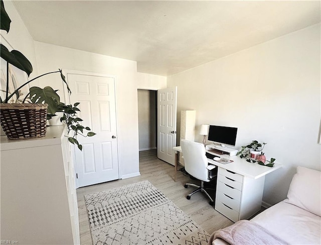 office space with baseboards and light wood-style floors