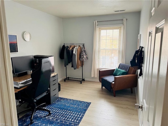 office area with visible vents, baseboards, and light wood-style floors