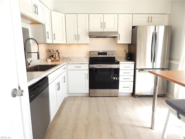 kitchen featuring under cabinet range hood, light countertops, appliances with stainless steel finishes, and a sink