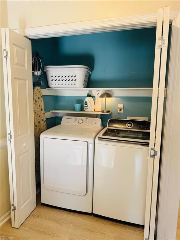 washroom featuring washer and dryer, light wood-style flooring, and laundry area