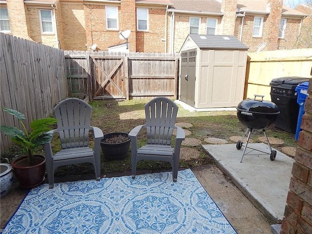 view of patio featuring an outbuilding, a shed, a grill, and a fenced backyard