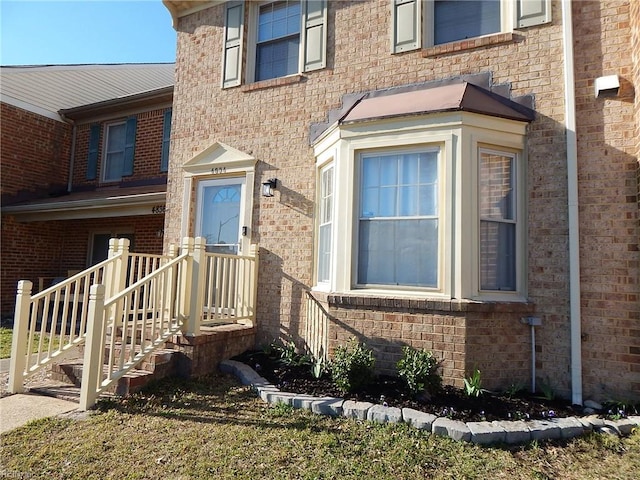 doorway to property featuring brick siding