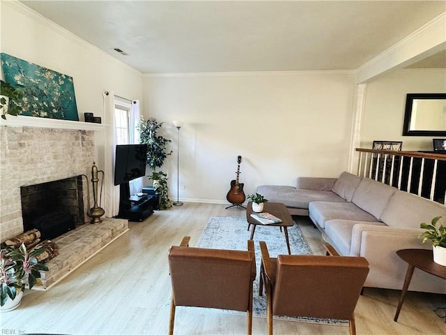 living area with wood finished floors, baseboards, visible vents, a fireplace, and ornamental molding