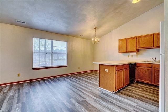 kitchen featuring dark wood-style floors, visible vents, a peninsula, and an inviting chandelier