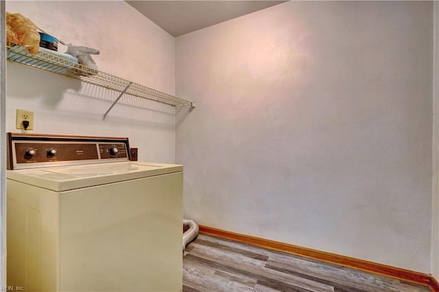 laundry room with laundry area, washer / dryer, baseboards, and wood finished floors