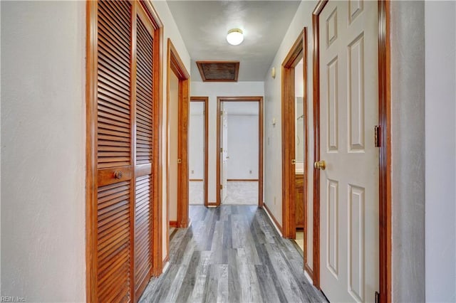 corridor with baseboards and wood finished floors