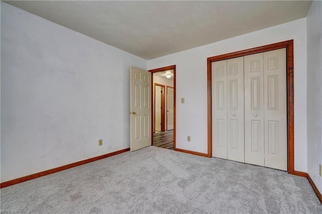 unfurnished bedroom featuring carpet flooring, baseboards, and a closet