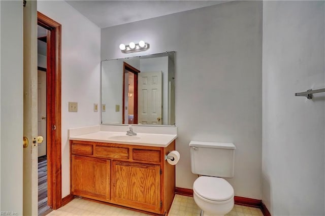 bathroom with vanity, tile patterned floors, toilet, and baseboards