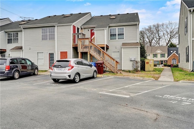 exterior space with stairway, a residential view, and uncovered parking