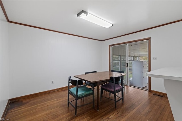 dining space with visible vents, dark wood-type flooring, baseboards, and ornamental molding