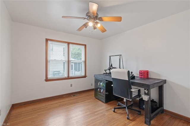 office space with light wood-type flooring, baseboards, visible vents, and a ceiling fan