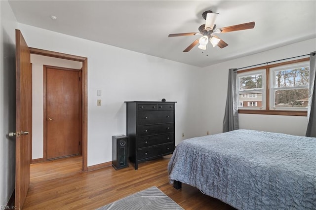 bedroom with wood finished floors, baseboards, and ceiling fan