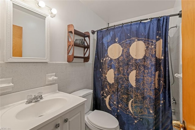 full bathroom with vanity, wainscoting, curtained shower, tile walls, and toilet