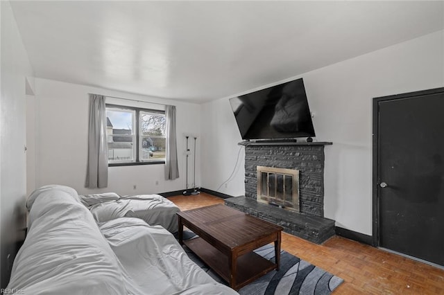 living room featuring a fireplace and baseboards