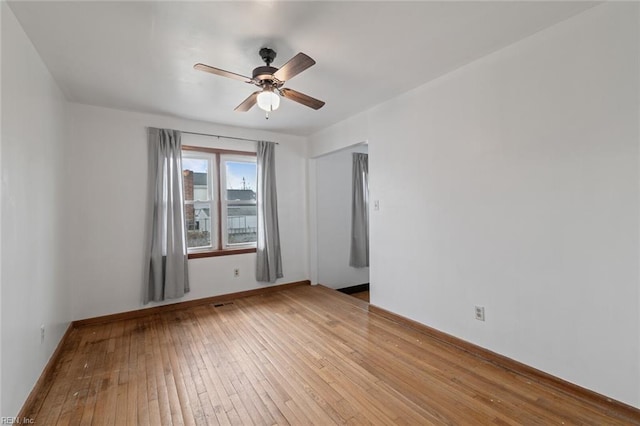 unfurnished room featuring baseboards, light wood-style floors, and a ceiling fan