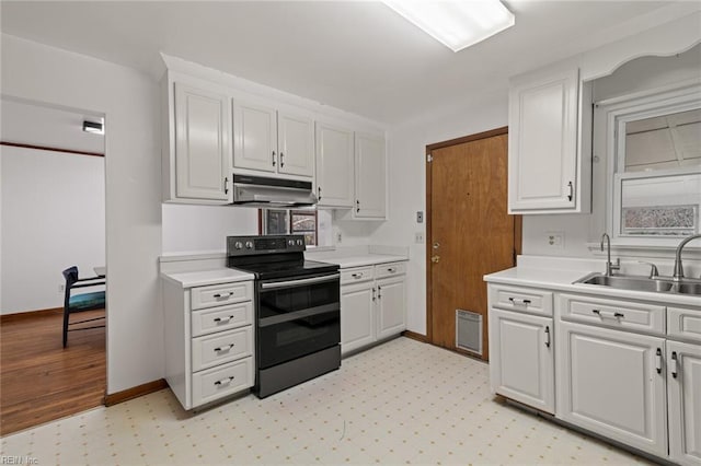 kitchen with range with electric cooktop, under cabinet range hood, a sink, white cabinets, and light countertops