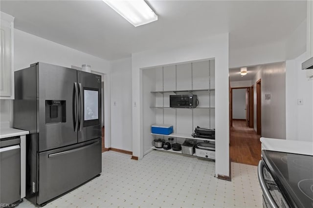 kitchen featuring light floors, appliances with stainless steel finishes, light countertops, and baseboards