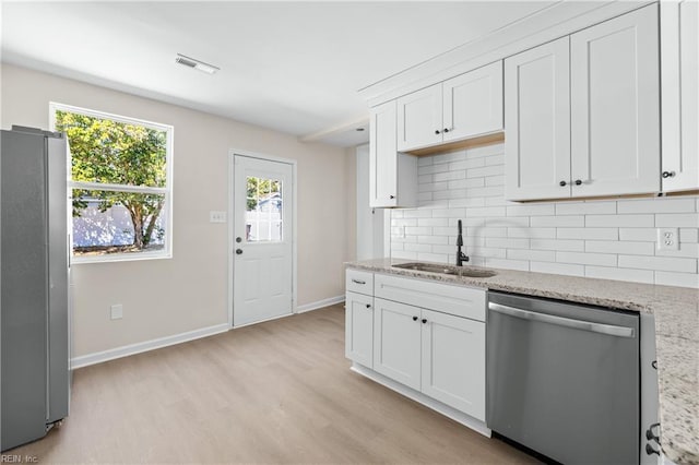 kitchen with visible vents, light wood-type flooring, a sink, appliances with stainless steel finishes, and decorative backsplash