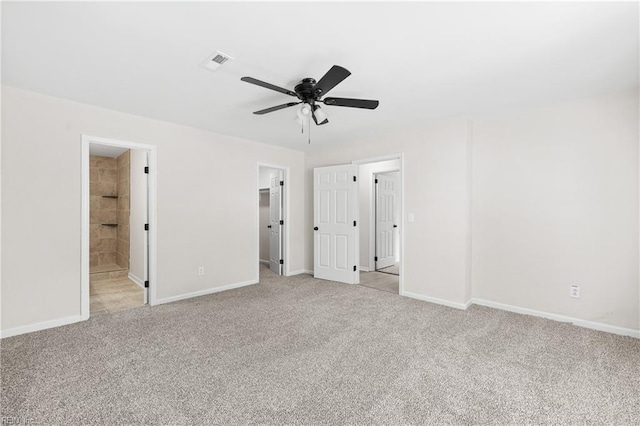 unfurnished bedroom with visible vents, a ceiling fan, baseboards, light colored carpet, and a spacious closet