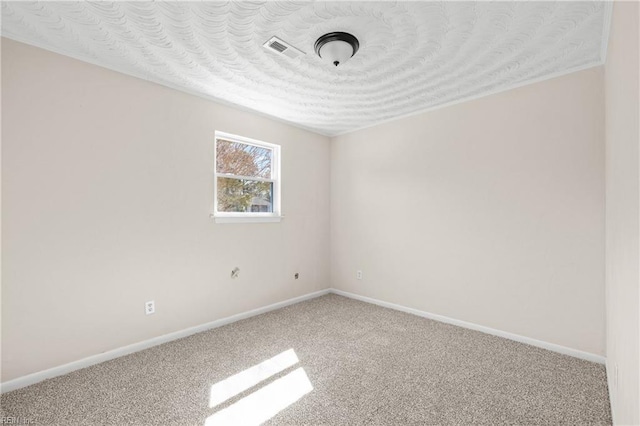 carpeted spare room with visible vents, a textured ceiling, and baseboards