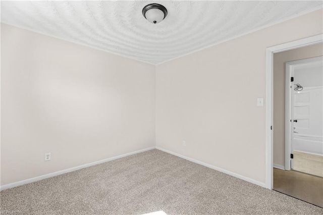 unfurnished room with baseboards and carpet flooring