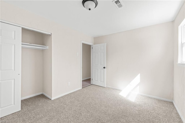 unfurnished bedroom featuring a closet, visible vents, baseboards, and carpet floors