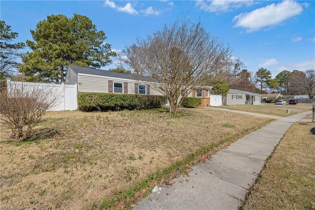 ranch-style home featuring a front yard and fence