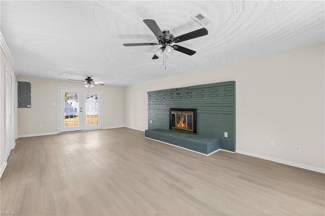 unfurnished living room featuring visible vents, light wood-style flooring, a textured ceiling, baseboards, and ceiling fan