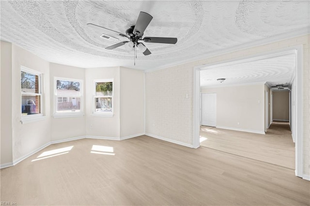 unfurnished room featuring a textured ceiling, brick wall, a ceiling fan, and light wood finished floors