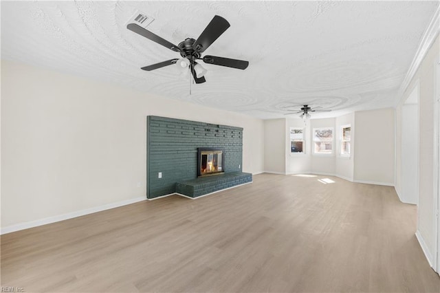 unfurnished living room featuring light wood finished floors, visible vents, a textured ceiling, and ceiling fan