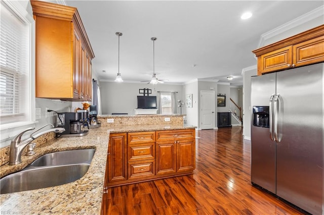 kitchen featuring stainless steel refrigerator with ice dispenser, a sink, a peninsula, crown molding, and ceiling fan