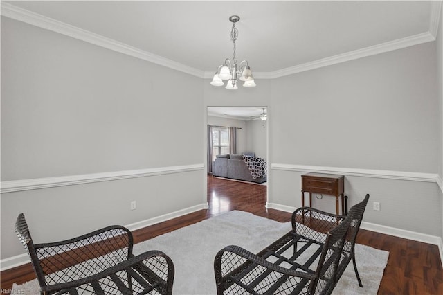 sitting room featuring baseboards, wood finished floors, crown molding, and ceiling fan with notable chandelier