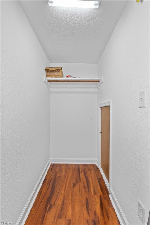 spacious closet featuring vaulted ceiling and wood finished floors