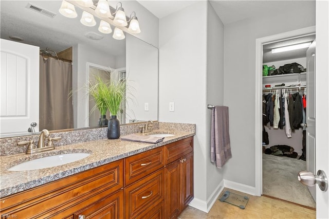 full bathroom with double vanity, visible vents, tile patterned floors, and a sink