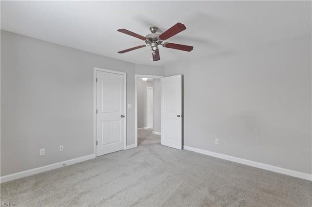 unfurnished room featuring carpet flooring, baseboards, and ceiling fan