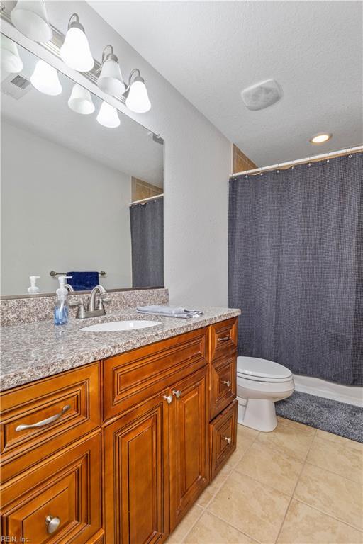 full bathroom with tile patterned floors, toilet, curtained shower, and vanity