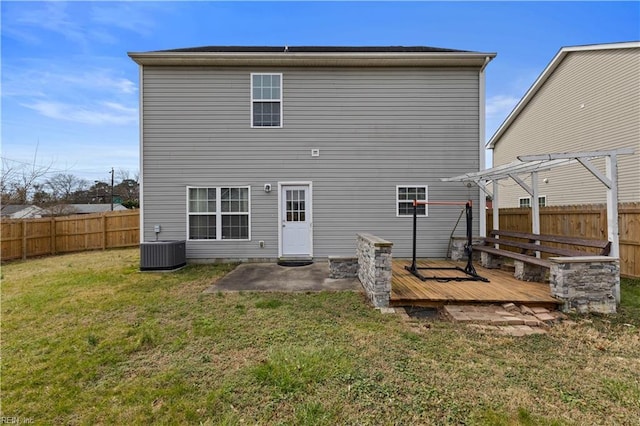 rear view of house with a yard, a wooden deck, central AC unit, and a fenced backyard