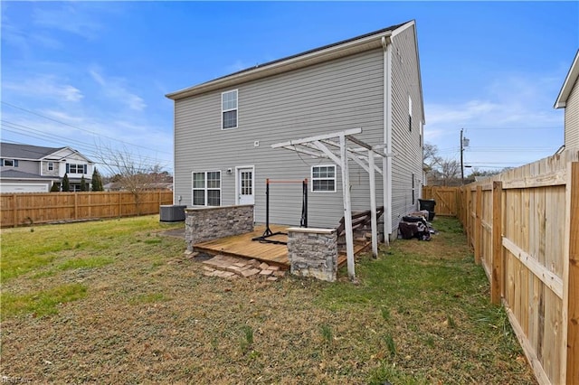 back of property featuring a deck, central air condition unit, a lawn, and a fenced backyard