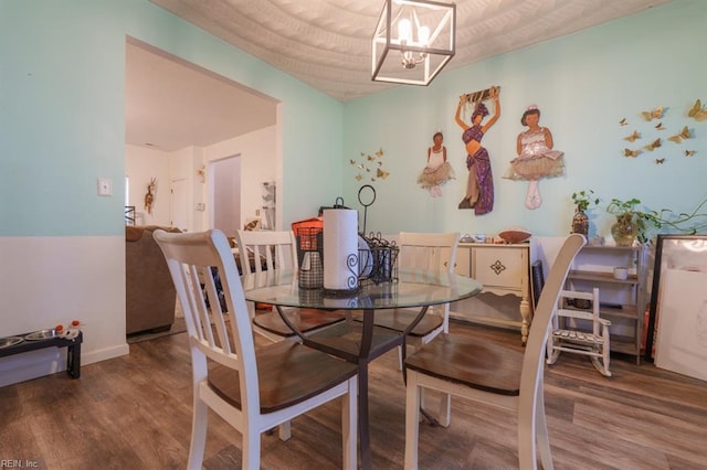 dining space with a chandelier and wood finished floors